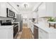 Bright white kitchen featuring stainless steel appliances, quartz countertops, and modern fixtures at 2044 Balfour Cir, Tampa, FL 33619