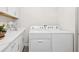 White laundry machines and countertops in this stylish laundry room at 2044 Balfour Cir, Tampa, FL 33619