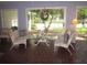 Sunroom featuring tile floors, glass table and views of the landscaped backyard through large windows at 2143 Wrens Way, Clearwater, FL 33764
