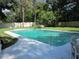 Beautiful in-ground pool surrounded by a spacious patio and lush landscaping at 2143 Wrens Way, Clearwater, FL 33764