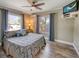 Cozy bedroom featuring a ceiling fan, television, and views of the outdoors at 2316 Lancaster Dr, Clearwater, FL 33764