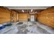 An empty garage with plywood walls and a sealed concrete floor, ready to be transformed to your liking at 2316 Lancaster Dr, Clearwater, FL 33764