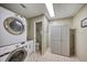Well-lit laundry room with a washer, dryer, storage cabinet, and tiled floors at 2316 Lancaster Dr, Clearwater, FL 33764