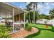Backyard featuring a covered lanai, putting green, and tropical landscaping at 2560 51St N St, St Petersburg, FL 33710