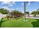 Putting green and covered lanai, surrounded by lush landscaping at 2560 51St N St, St Petersburg, FL 33710