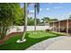 Backyard putting green with lush landscaping and a view of the lanai at 2560 51St N St, St Petersburg, FL 33710