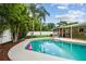 Putting green and pool, surrounded by lush landscaping and palm trees at 2560 51St N St, St Petersburg, FL 33710