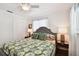 Bedroom featuring a grey upholstered bed frame, floral comforter, side tables, closet, and natural lighting at 2560 51St N St, St Petersburg, FL 33710