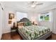Bedroom featuring a grey upholstered bed frame, floral comforter, side tables, and natural lighting at 2560 51St N St, St Petersburg, FL 33710