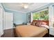 Cozy bedroom featuring hardwood floors, large window, ceiling fan, and a comfortable bed at 2560 51St N St, St Petersburg, FL 33710