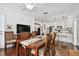 Open-concept dining room flowing into the kitchen area, featuring a wooden table with chairs and hardwood floors at 2560 51St N St, St Petersburg, FL 33710