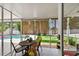 Inviting screened patio with roll down shades, a dining set, and a view of the pool and putting green at 2560 51St N St, St Petersburg, FL 33710