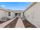Paver driveway leading to the garage with landscaped beds, featuring modern, energy-efficient air conditioning units at 27132 Capri Shores Cir, Englewood, FL 34223