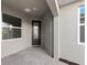 Cozy front porch with stone-paved flooring and a welcoming doormat, next to large picture windows at 27132 Capri Shores Cir, Englewood, FL 34223