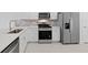 Modern kitchen with stainless steel appliances, quartz countertops, white cabinetry and mosaic backsplash at 27132 Capri Shores Cir, Englewood, FL 34223