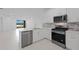 Stylish kitchen with stainless steel appliances, quartz countertops, white cabinetry and island with sink at 27132 Capri Shores Cir, Englewood, FL 34223
