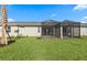 Backyard with well-maintained lawn features a screened lanai with access to the house at 27136 Capri Shores Cir, Englewood, FL 34223