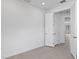 Bright bedroom featuring neutral walls, base molding, and gray tile flooring, with door that leads to hallway at 27136 Capri Shores Cir, Englewood, FL 34223