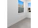 Bright bedroom with large windows, neutral walls, base molding, and gray tile flooring providing a clean aesthetic at 27136 Capri Shores Cir, Englewood, FL 34223