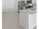 A modern kitchen featuring gray tile floors, stainless steel appliances, and a kitchen island at 27136 Capri Shores Cir, Englewood, FL 34223