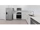 Modern kitchen with stainless steel appliances, white cabinets, and quartz countertops at 27136 Capri Shores Cir, Englewood, FL 34223