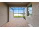 Screened lanai with pavers offers a serene view of the pond and natural surroundings beyond at 27136 Capri Shores Cir, Englewood, FL 34223