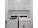 Well-lit laundry room featuring modern washer and dryer, and upper cabinets offering extra storage at 27136 Capri Shores Cir, Englewood, FL 34223