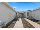 Exterior side view of the home showcasing pathway, lawn, and architectural details at 27136 Capri Shores Cir, Englewood, FL 34223