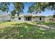 Home's backyard features a screened patio, partial fencing, and mature trees at 2719 Wilder Trace Ct, Plant City, FL 33566