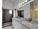 Updated bathroom featuring a double vanity with granite countertops and a tiled shower at 2719 Wilder Trace Ct, Plant City, FL 33566
