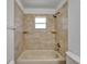 Full bathroom with tiled shower over tub, tiled walls, and neutral colored fixtures at 2719 Wilder Trace Ct, Plant City, FL 33566