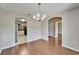 Charming dining area with wood floors, chandelier, and open access to kitchen and hallway at 2719 Wilder Trace Ct, Plant City, FL 33566