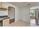 Bright kitchen features tile floors, neutral cabinets, and arched doorways to other rooms at 2719 Wilder Trace Ct, Plant City, FL 33566
