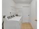 Functional laundry room with washer, dryer, shelving, and tile flooring for easy cleaning at 2719 Wilder Trace Ct, Plant City, FL 33566