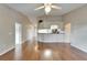 Spacious living area featuring wood floors, a ceiling fan, and a seamless flow to the kitchen at 2719 Wilder Trace Ct, Plant City, FL 33566