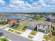 An aerial view showcasing a home with attached garage in a lakeside community at 3186 Oyster Cove St, Wimauma, FL 33598
