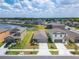 An aerial view showcases a home with attached garage in a lakeside neighborhood with lush lawns at 3186 Oyster Cove St, Wimauma, FL 33598