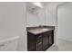 A second bathroom showing a modern vanity with dark cabinetry, granite countertops, and a white toilet at 3186 Oyster Cove St, Wimauma, FL 33598