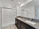 Modern bathroom featuring walk-in shower with glass door and double vanity with granite countertops at 3186 Oyster Cove St, Wimauma, FL 33598