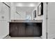 Bathroom with a granite-topped double vanity, framed mirror, walk-in shower, and a door leading to a toilet room at 3186 Oyster Cove St, Wimauma, FL 33598