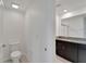 Bathroom with neutral tile, granite countertops, dark brown cabinets, toilet and large mirror at 3186 Oyster Cove St, Wimauma, FL 33598