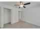 This bedroom features neutral carpeting, a ceiling fan, and a closet for ample storage at 3186 Oyster Cove St, Wimauma, FL 33598