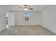 An unfurnished bedroom with neutral carpet, white walls, a window and doorway at 3186 Oyster Cove St, Wimauma, FL 33598