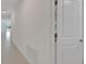 Bright hallway featuring neutral tile flooring and a glimpse into the spacious, light-filled living areas at 3186 Oyster Cove St, Wimauma, FL 33598