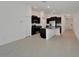 Contemporary kitchen boasts dark cabinets, granite counters, and stainless appliances in an open layout at 3186 Oyster Cove St, Wimauma, FL 33598