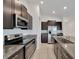Well-equipped kitchen with stainless steel appliances, dark cabinets, and granite countertops at 3186 Oyster Cove St, Wimauma, FL 33598