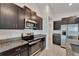 Well-equipped kitchen with stainless steel appliances, dark cabinets, and granite countertops at 3186 Oyster Cove St, Wimauma, FL 33598