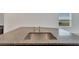 Close up on kitchen island sink with granite countertops, modern faucet and stainless steel basin at 3186 Oyster Cove St, Wimauma, FL 33598