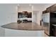 Modern kitchen featuring a large island with granite countertops and stainless steel appliances at 3186 Oyster Cove St, Wimauma, FL 33598