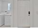 This laundry room features a window, washer and dryer, and a door to another room at 3186 Oyster Cove St, Wimauma, FL 33598